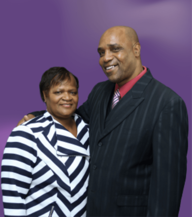 Pastor William Buck and Brenda Buck posing together, both smiling, against a purple background.